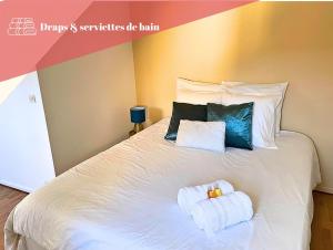 ein Schlafzimmer mit einem weißen Bett und Handtüchern darauf in der Unterkunft Appart cosy rénové avec AC Hypercentre Nemours in Nemours