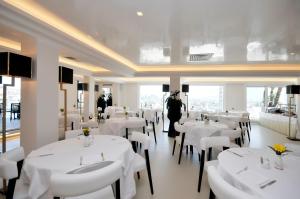 une salle à manger avec des tables et des chaises blanches dans l'établissement Grand Hotel Oriente, à Naples