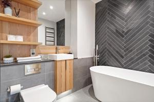 a bathroom with a tub and a toilet and a sink at Cosy London Retreat - Sleeps 6 in London