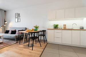 a kitchen and living room with a table and a couch at Apartamenty Tespis - Francuska Atal Park II in Katowice