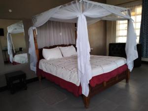 a bedroom with a bed with a canopy at BIMOSS BEACH RESORT in Mbita