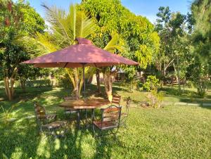 a table and chairs under an umbrella in the grass at BIMOSS BEACH RESORT in Mbita