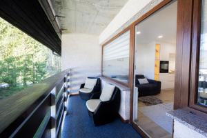 克拉尼斯卡戈拉Relax Studio Kranjska Gora的客房设有带椅子的阳台和客厅。