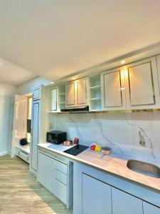 a kitchen with white cabinets and a counter top at Apartmen Sea View Lampung Mall 