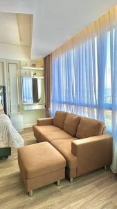 a living room with a couch and blue curtains at Apartmen Sea View Lampung Mall 