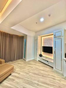 a living room with a large window and a television at Apartmen Sea View Lampung Mall 