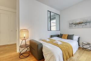 Dormitorio blanco con cama y lámpara en Chic and Warm 1 bd Flat - Heart of the Luxury 16th en París