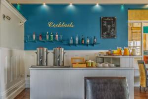 a bar in a restaurant with a blue wall at Muthu Westcliff Hotel (Near London Southend Airport) in Southend-on-Sea