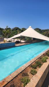 a large swimming pool with a white umbrella at Umhlanga Breakers Resort in Durban