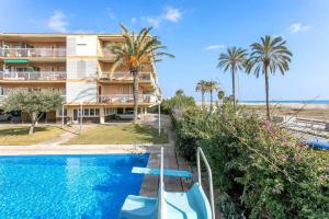 un complexe avec une piscine et des palmiers dans l'établissement Canela Homes COSTA CASTELLDEFELS, à Castelldefels