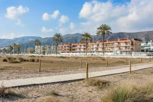 ein Gebäude auf einem Feld mit Palmen in der Unterkunft Canela Homes COSTA CASTELLDEFELS in Castelldefels