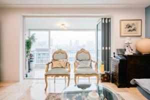 a living room with two chairs and a glass table at Garosugil Homestay - Female Only in Seoul