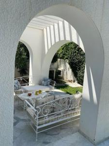 Villa de maitre magnifique, spacieuse avec jardin في المرسى: ممر أبيض مع طاولة في الفناء