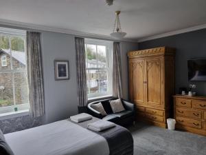 een slaapkamer met een bed, een kast en een stoel bij Fellview Guest House in Bowness-on-Windermere