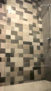 a bathroom with a shower with a tiled wall at Apartamento primera línea mar Garachico in Garachico