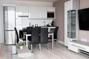 una cucina con tavolo e sedie nere di Apartamento primera línea mar Garachico a Garachico Altre 3 foto