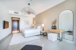 a bedroom with a bed and a table and a mirror at Vogue Downtown - Opera Grand - Burj Khalifa & Fountain Views in Dubai +73 photos