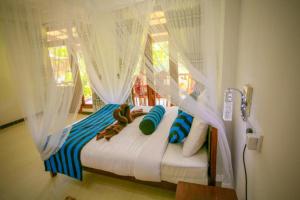 a bedroom with a canopy bed with blue and white pillows at Blue Heaven Cottage in Ella