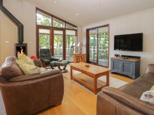 a living room with two couches and a tv at Leafy Nook Lodge in Ambleside