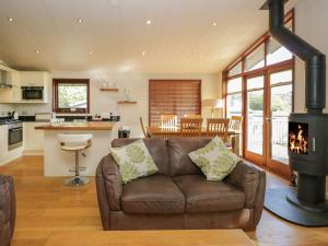 a living room with a couch and a stove at Leafy Nook Lodge in Ambleside