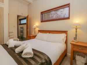 una camera da letto con un letto e asciugamani di Leafy Nook Lodge ad Ambleside