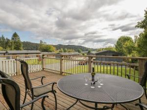 a table and chairs on a wooden deck at Leafy Nook Lodge in Ambleside