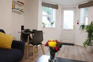 a living room with a vase of flowers on a table at Flat 1, Allerton House in Leeds