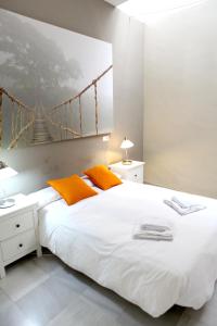 - une chambre avec un grand lit blanc et un pont sur le mur dans l'établissement Sleepin Sevilla Catedral, à Séville