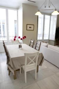 uma sala de jantar branca com uma mesa e cadeiras brancas em Sleepin Sevilla Catedral em Sevilha