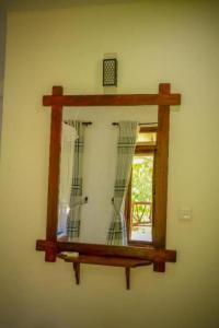 un espejo colgado en una pared con una ventana en Blue Heaven Cottage en Ella