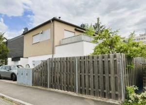 a wooden fence in front of a house at Sylvis Home Zentral gelegenes Ferienhaus in ruhiger Lage in Fürth