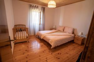 a bedroom with a bed and a crib in it at Violet's Place in Črni Kal