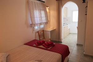 a bedroom with a bed with red pillows on it at Afroditi studios in Kampos Paros