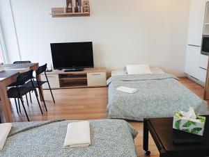 a living room with two beds and a flat screen tv at Apartman Bystrc in Brno