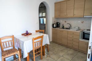 - une cuisine avec une table, des chaises et un évier dans l'établissement Afroditi studios, à Kampos Paros