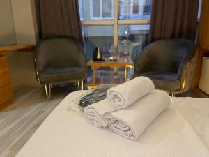 zwei Handtücher auf einem Bett mit zwei Stühlen in der Unterkunft DNC REZİDANCE in Konak