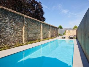una piscina di fronte a un muro di mattoni di Notarishuys "Pure Hotel" a Diksmuide
