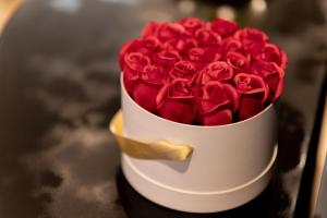 アグドにあるLA PERLE NOIREの赤いバラが満ちた白い花瓶