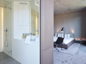 una camera da letto con un letto e un bagno con un lavandino di Notarishuys "Pure Hotel" a Diksmuide