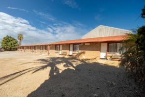 ArdrossanArdrossan Hotel Motel的一座前面有棕榈树的建筑