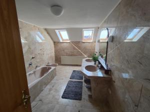 a bathroom with a bath tub and a sink and a bath tub at Richie's Landhaus im Allgäu in Pfaffenhausen