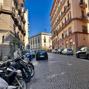 een rij motorfietsen geparkeerd in een stadsstraat bij Elegance Rooms Spaccanapoli in Napels