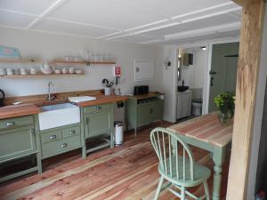 a kitchen with green cabinets and a wooden floor at Newchurch Nook in Newchurch