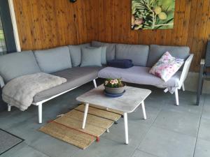 a couch sitting on a patio with a table at Chalet "Het Biggetje" met hottub in Volkel