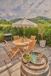 einen Tisch und Stühle mit Sonnenschirm auf einer Terrasse in der Unterkunft The Pump House in Ashington