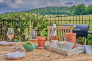 a table with glasses and bottles of wine on it at The Pump House At Wiston Estate in Ashington