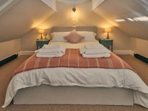 a bedroom with a large bed with towels on it at The Pump House in Ashington