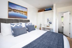 1 dormitorio con 1 cama grande con almohadas azules y blancas en 6 The Bay en Coldingham