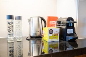 Voyage One Bedroom In Fairmont في أبوظبي: كونتر توب مع آلة صنع القهوة وآلة صنع القهوة