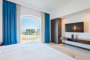 ein Schlafzimmer mit einem großen Bett und einem großen Fenster in der Unterkunft Voyage One Bedroom In Fairmont in Abu Dhabi